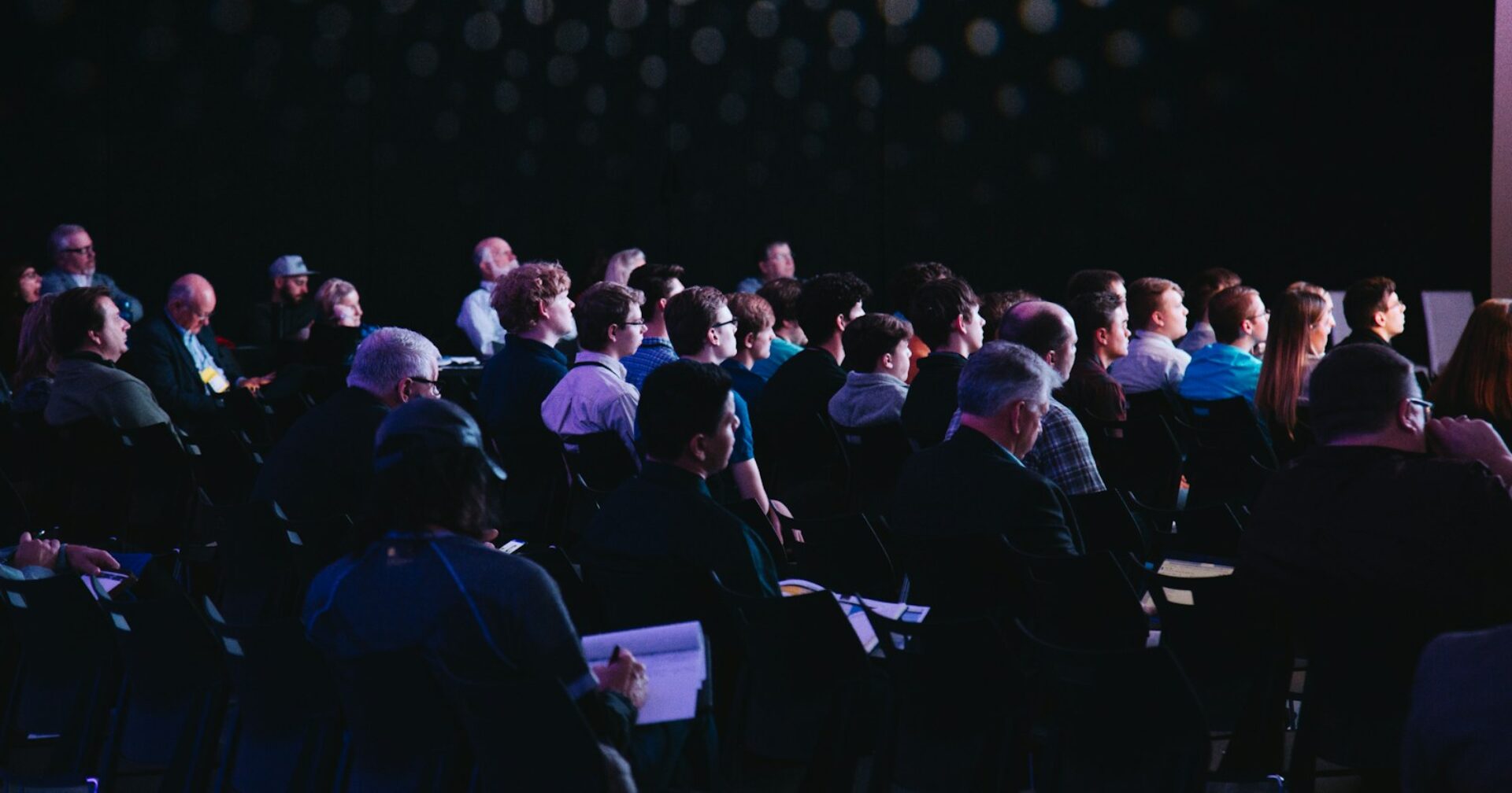 crowd of people sitting on chairs inside room